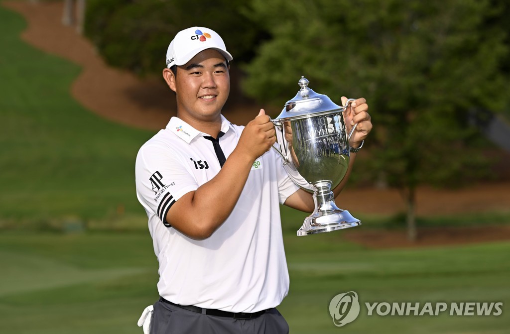 In this Getty Images file photo from Aug. 7, 2022, Kim Joo-hyung of South Korea hoists the champion's trophy after winning the Wyndham Championship at Sedgefield Country Club in Greensboro, North Carolina. (Yonhap)