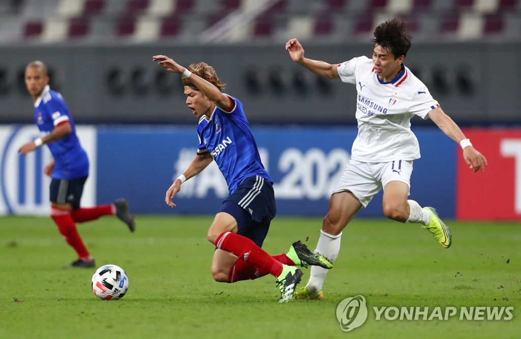 In this Reuters photo, Lim Sang-hyub of Suwon Samsung Bluewings (R) is in action against Takahiro Ogihara of Yokohama F. Marinos in the round of 16 at the Asian Football Confederation Champions League at Khalifa International Stadium in Doha on Dec. 7, 2020. (Yonhap)