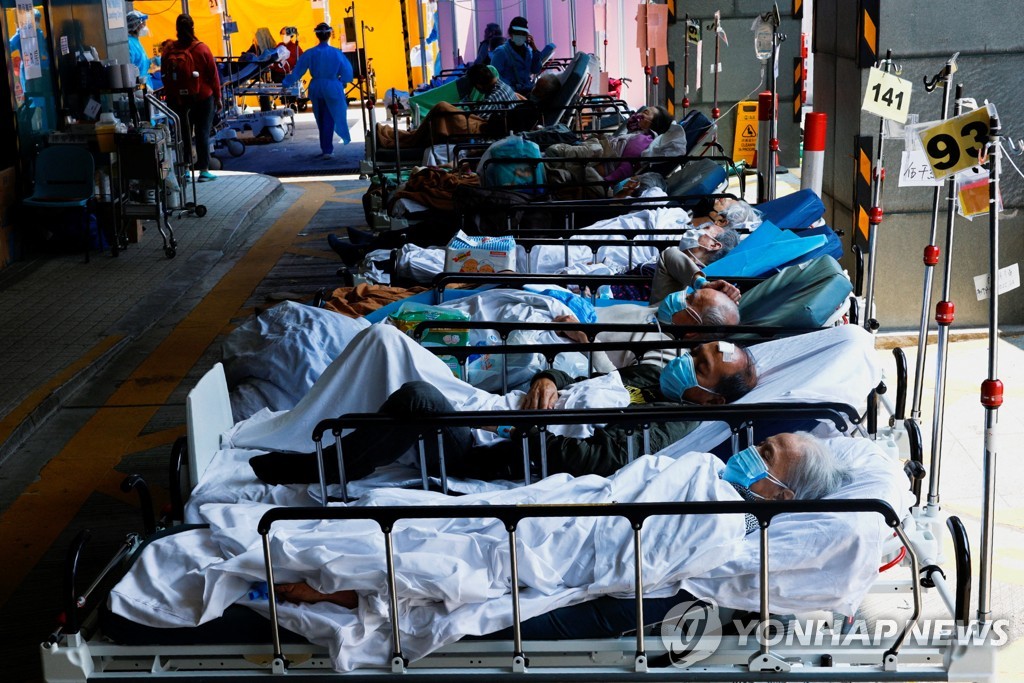 (로이터=연합뉴스) 지난 2일 홍콩의 한 병원 밖 임시 공간에 코로나19 환자들이 침대에 누운 채 대기하는 모습. 2022.3.2.