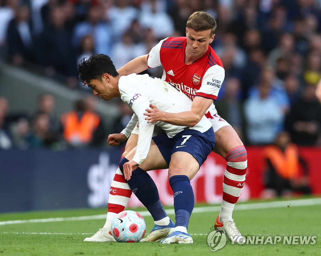 In this Reuters photo, Son Heung-min of Tottenham Hotspur (L) battles Rob Holding of Arsenal for the ball during the clubs' Premier League match at Tottenham Hotspur Stadium in London on May 12, 2022. (Yonhap)