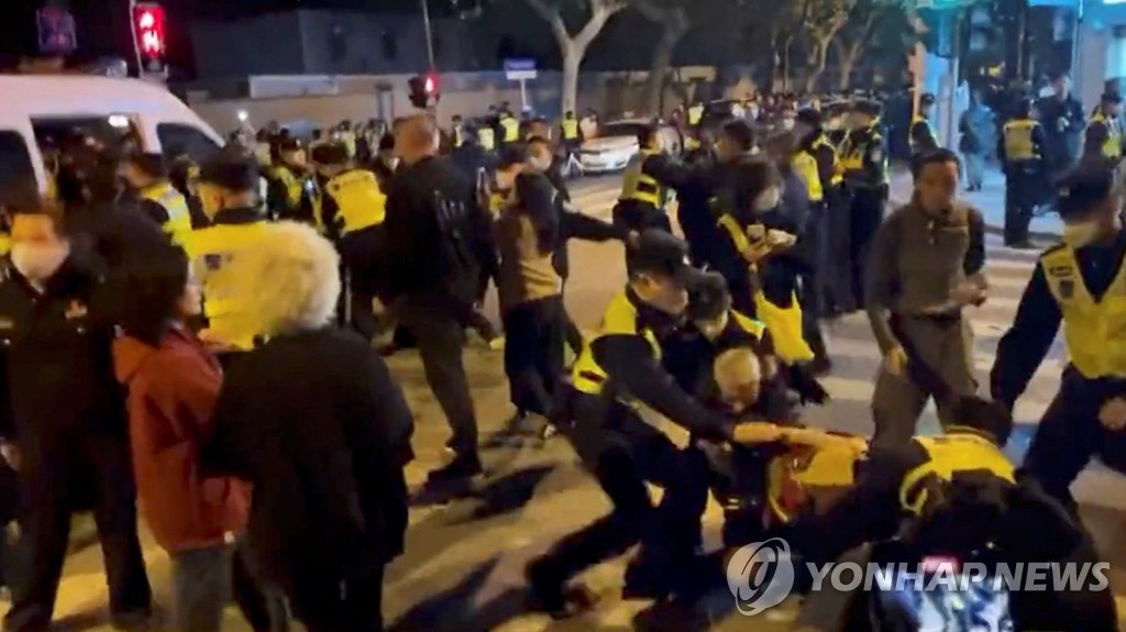 (상하이 로이터=연합뉴스) 지난 26일 중국 상하이에서 벌어진 코로나19 방역 항의 시위 현장에서 경찰이 사람들을 연행하고 있다.