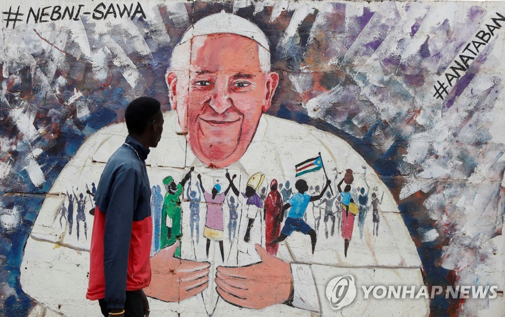 프란치스코 교황의 방문을 앞두고 남수단 수도 주바 거리에서 한 남성이 교황을 묘사한 벽화를 바라보고 있다.