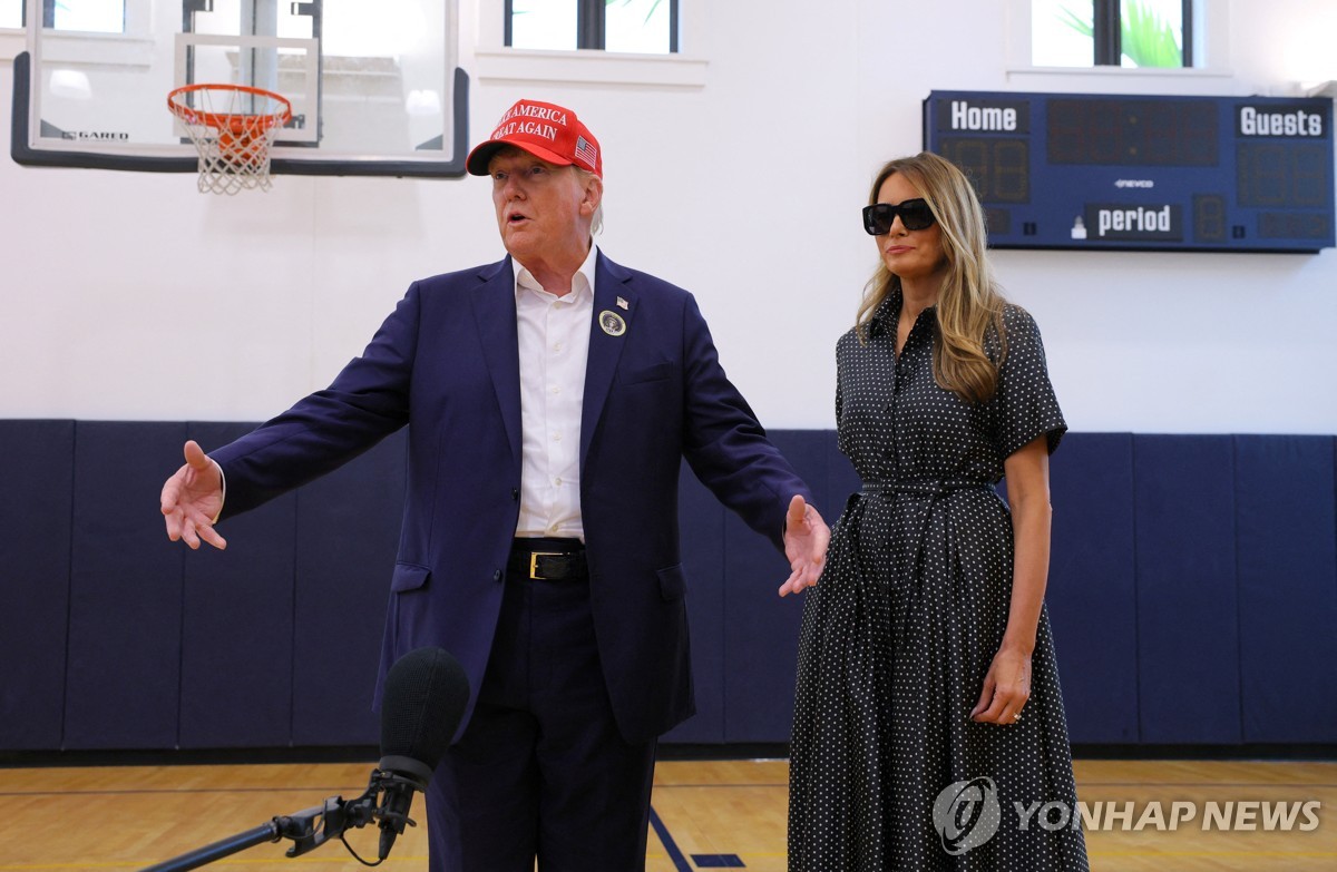 El expresidente estadounidense Donald Trump, acompañado por la exprimera dama Melania Trump, habla con los periodistas mientras vota en el Centro Recreativo Mandel el día de las elecciones en Palm Beach, Florida, el 5 de noviembre de 2024, en esta fotografía publicada por Reuters. (Yonhap)