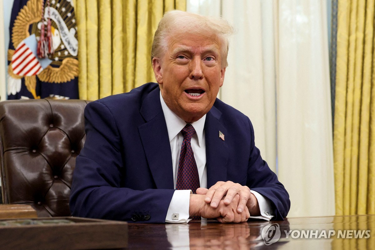 Reuters'ın yayımladığı bu fotoğrafta, ABD Başkanı Donald Trump, 23 Ocak 2025'te Washington'daki Beyaz Saray'ın Oval Ofisi'nde oturmuş, yürütme kararnamelerini imzalıyor. (Yonhap)