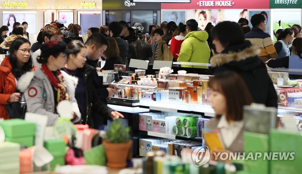 ソウル市内の免税店で買い物する中国人観光客ら＝（聯合ニュース）