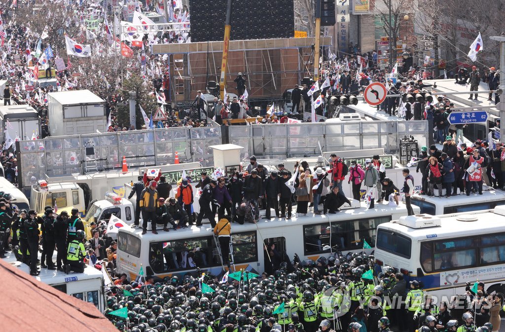 警察のバスに上る弾劾反対集会の参加者＝１０日、ソウル（聯合ニュース）