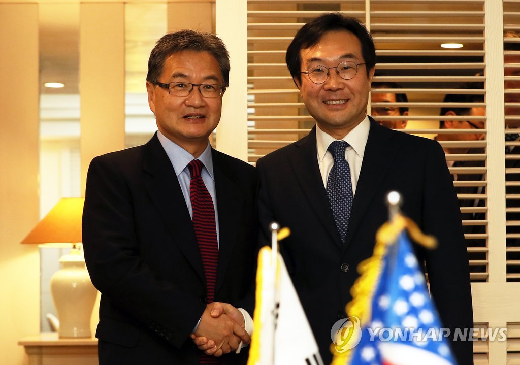 握手を交わす李本部長（右）とユン特別代表＝１７日、済州（聯合ニュース）