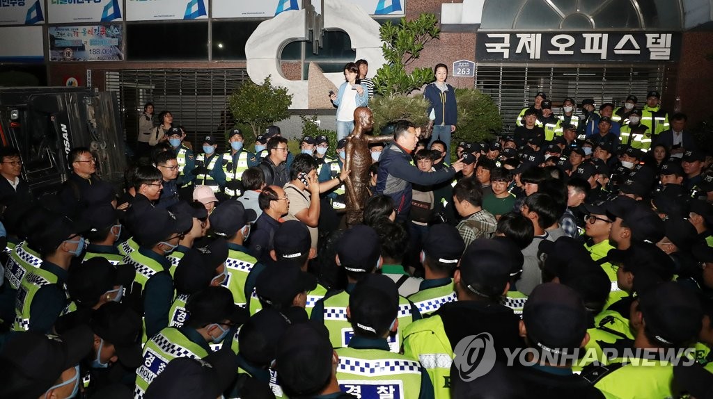 日本総領事館館の手前１００メートルほどのところで、労働者像を運ぶ市民団体を警察が阻止している＝３０日、釜山（聯合ニュース）