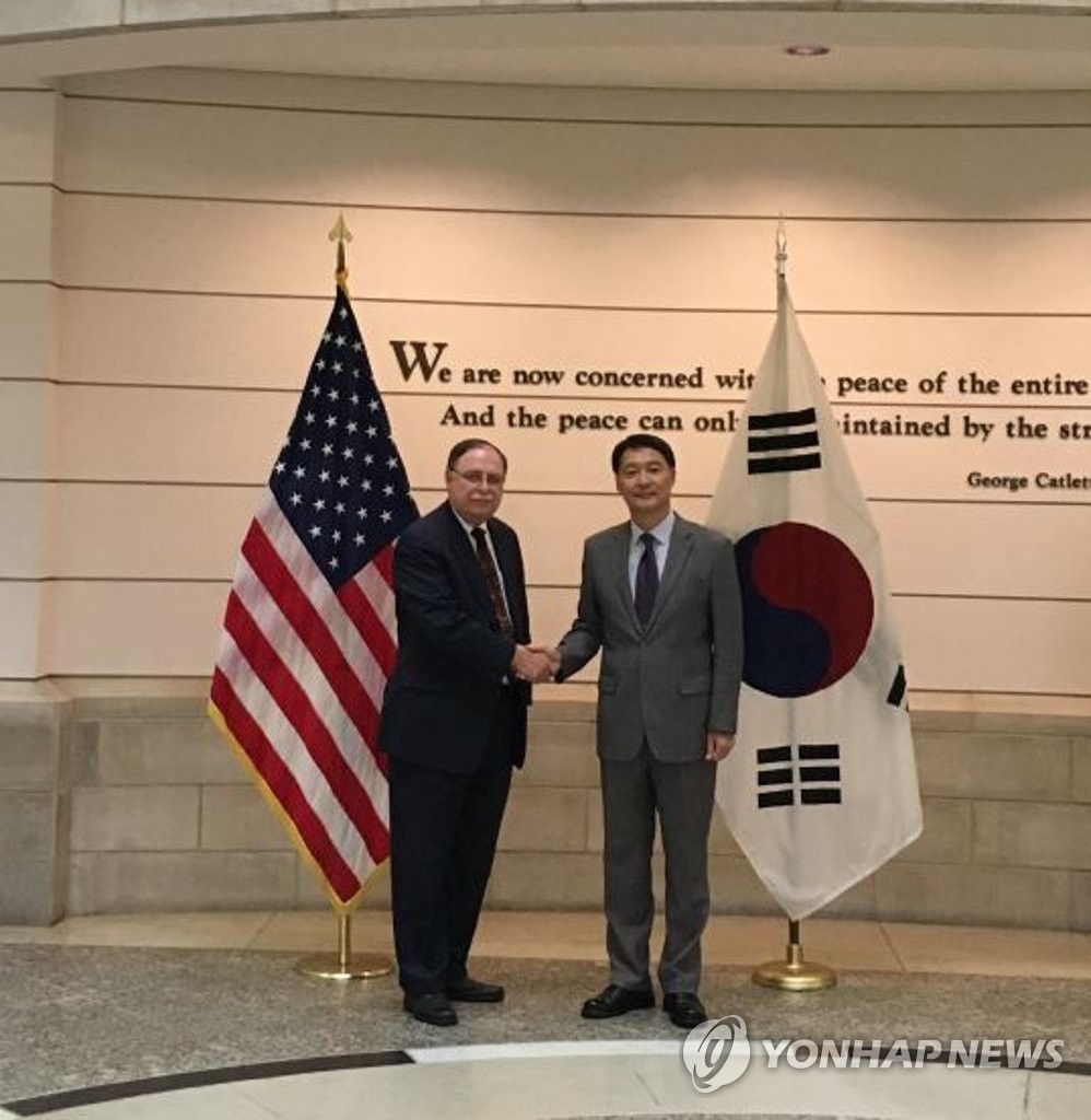 Chang Won-sam (R), South Korea's top negotiator on sharing defense costs with the United States, shakes hands with his counterpart Timothy Betts in this undated file photo released by Seoul's foreign ministry. (Yonhap)