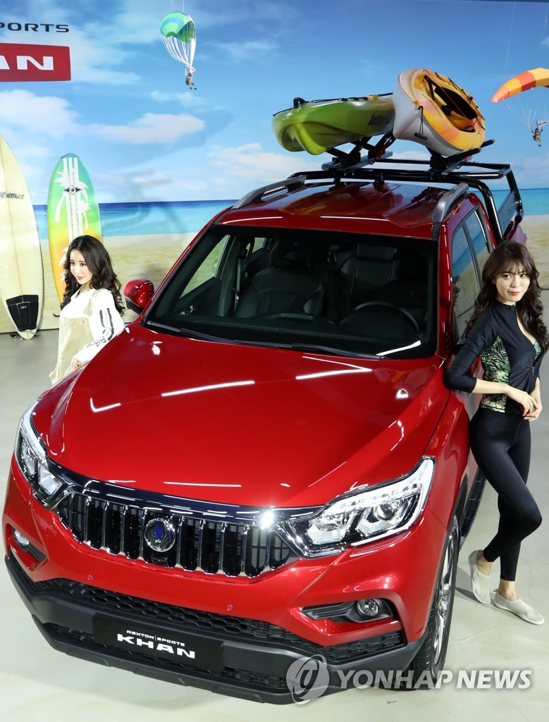 In this photo taken on Jan. 3, 2019, models pose beside the Rexton Sports Khan SUV at a media event held in eastern Seoul. (Yonhap)