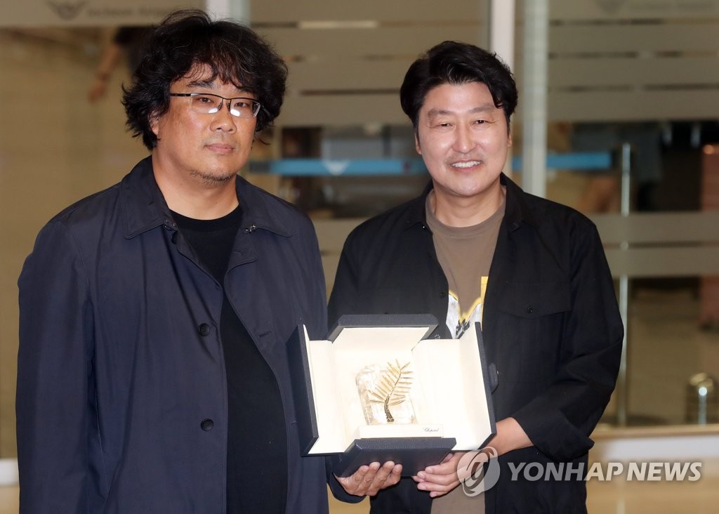 Le réalisateur sud-coréen Bong Joon-ho (à g.) et l'acteur Song Kang-ho présentent la Palme d'or lors d'une rencontre avec des journalistes à l'aéroport international d'Incheon, à l'ouest de Séoul, le 27 mai 2019, à leur retour de Cannes, en France. Bong a remporté le prix pour son film «Parasite» lors de la 72e édition du Festival de Cannes la veille.