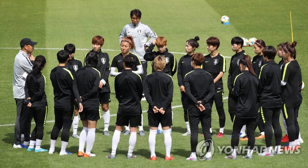 Members of the South Korean women's national football team huddle around their head coach Yoon Duk-yeo (far left, grey top) before practice at Stade Louis Boury in Gennevilliers, France, on June 3, 2019, in preparation for the FIFA Women's World Cup. (Yonhap)
