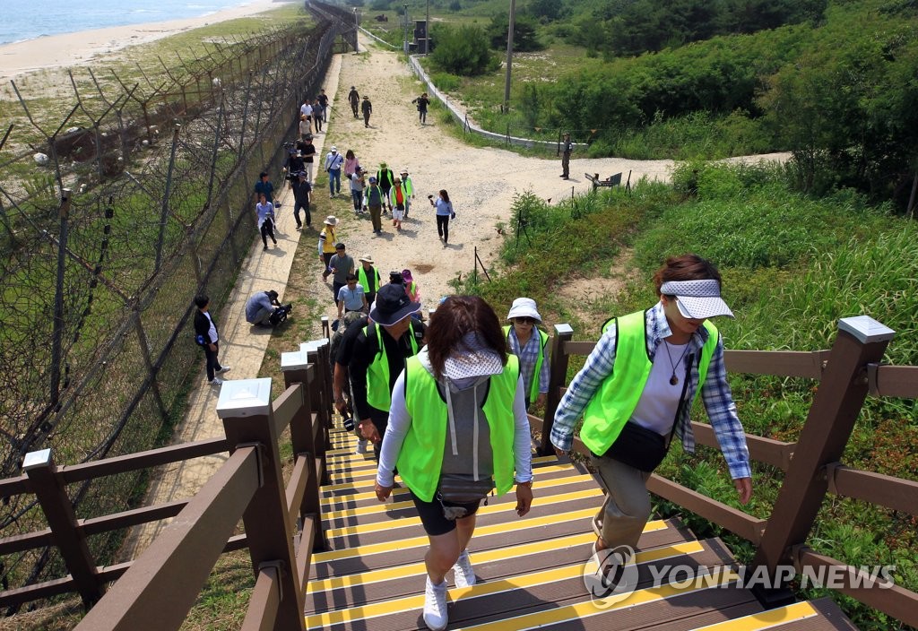 In this file photo, taken June 26, 2019, tourists walk along a trail adjacent to the Demilitarized Zone (DMZ), named the DMZ Peace Trail, in the northeastern border county of Goseong, nearly two months after its opening. (Yonhap)