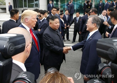 In this file photo, taken June 30, 2019, South Korean President Moon Jae-in (R) meets North Korean leader Kim Jong-un (C), alongside U.S. President Donald Trump, at the truce village of Panmunjom in the Demilitarized Zone, which separates the two Koreas. (Yonhap) 