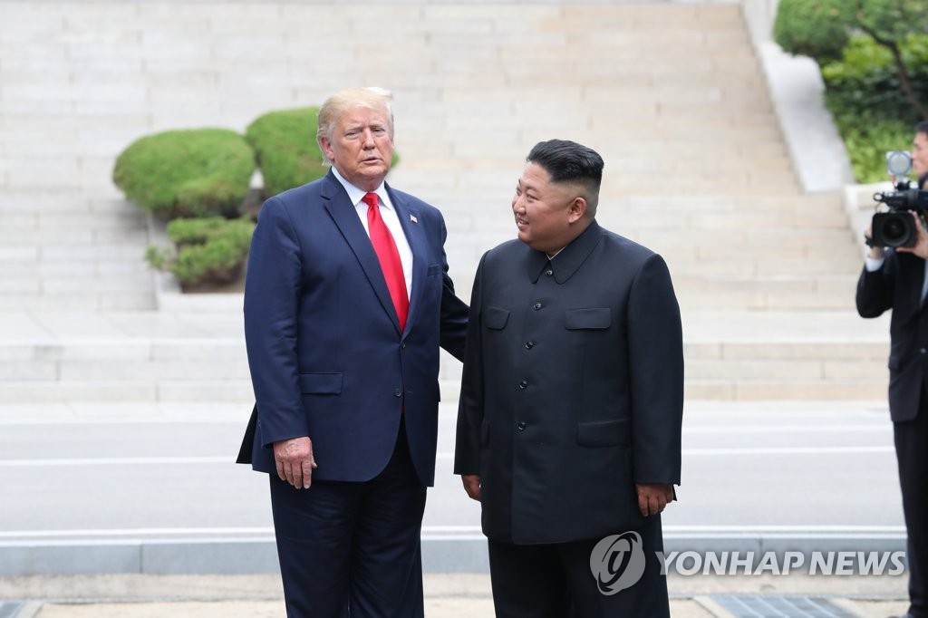 U.S. President Donald Trump (L) talks with North Korean leader Kim Jong-un after crossing the Military Demarcation Line into the North's side at the truce village of Panmunjom in the Demilitarized Zone, which separates the two Koreas, on June 30, 2019. Trump became the first sitting U.S. president to step onto North Korean soil. (Yonhap)