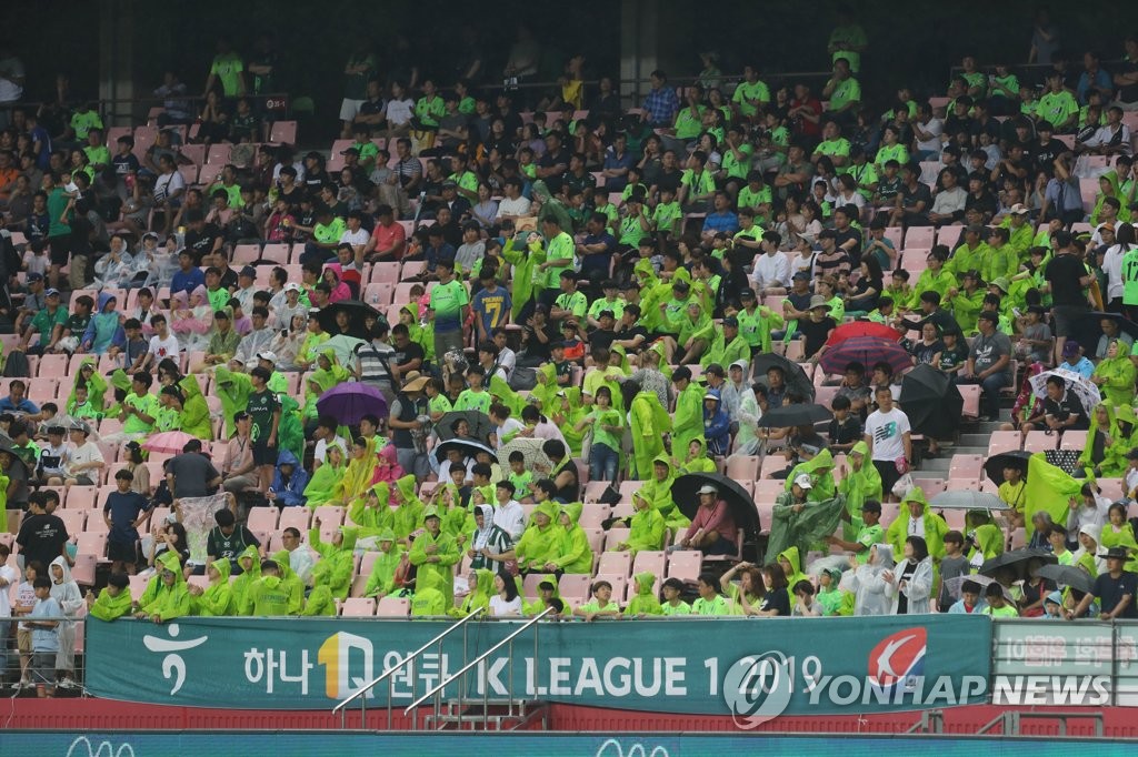 In this file photo from July 7, 2019, fans of Jeonbuk Hyundai Motors at Jeonju World Cup Stadium in Jeonju, 240 kilometers south of Seoul, brave the rain during the home club's K League 1 Match against Seongnam FC. (Yonhap)