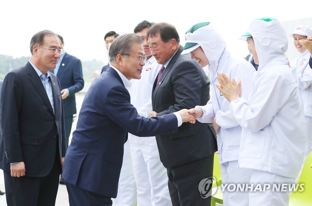 President Moon Jae-in shakes hands with an employee of Harim Group during his visit to its headquarters in Iksan, North Jeolla Province, on Aug. 20, 2019. (Yonhap)