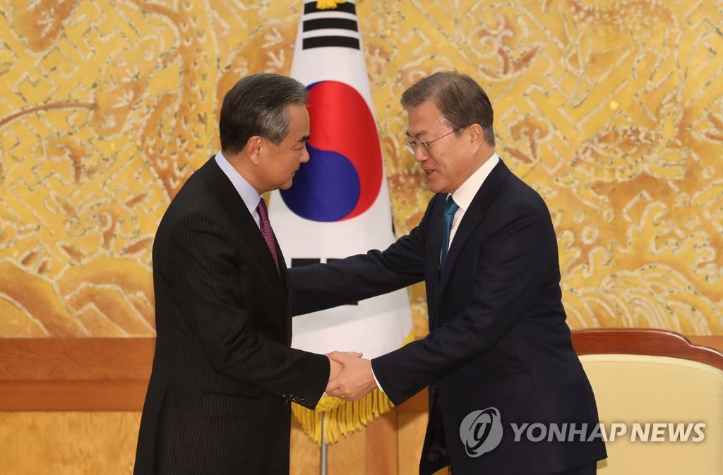 In this file photo from Dec. 5, 2019, South Korean President Moon Jae-in (R) shakes hands with Chinese Foreign Minister Wang Yi at Cheong Wa Dae in Seoul. (Yonhap)