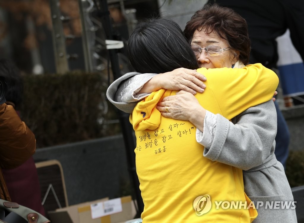 Lee Yong-su (R) hugs Yoon Mi-hyang, leader of the Korean Council for Justice and Remembrance for the Issues of Military Sexual Slavery by Japan, a civic group advocating for the victims, at the weekly Wednesday rally held on Jan. 8, 2020. (Yonhap)