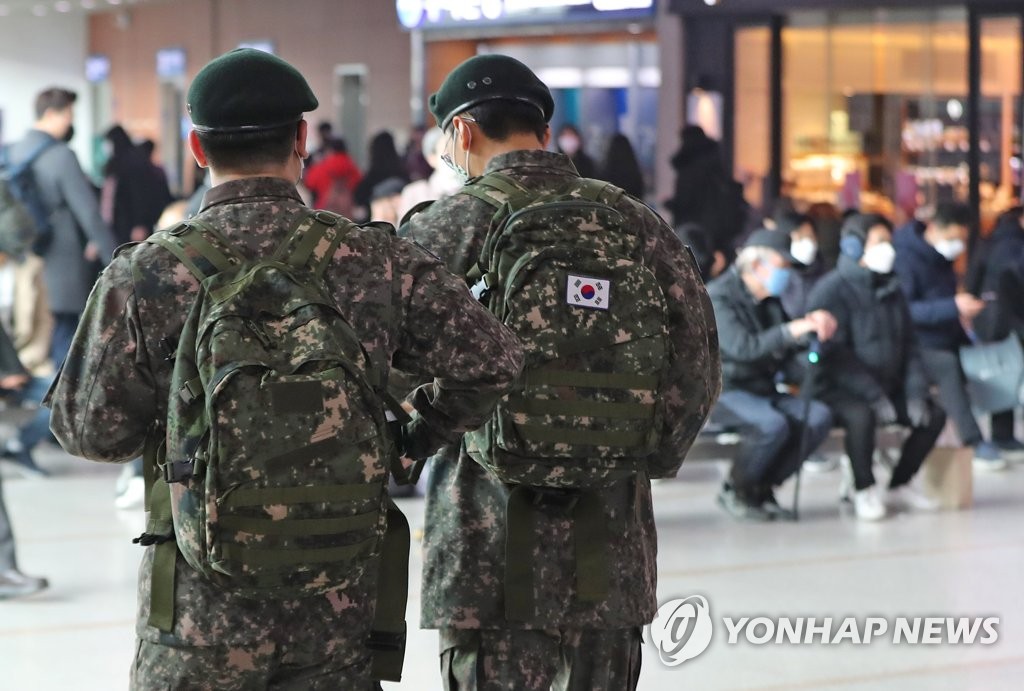 This file photo taken Feb. 21, 2020, shows service members walking at Seoul Station in central Seoul. (Yonhap)