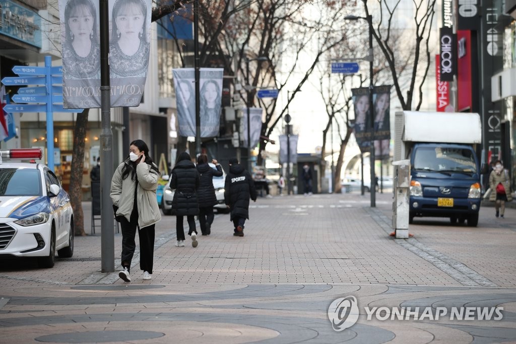 Pedestrians walk on an empty street in Myeongdong, a popular Seoul shopping district, on Feb. 29, 2020. (Yonhap)
