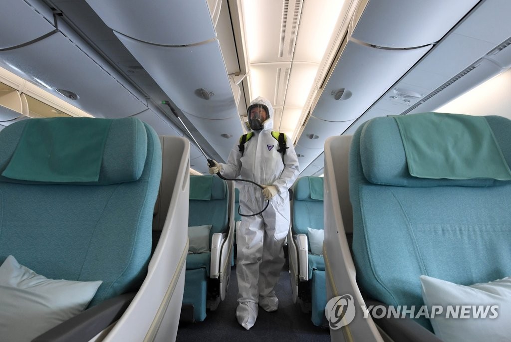 A health worker disinfects the cabin of a Korean Air Lines Co. aircraft at Incheon International Airport in Incheon, west of Seoul, in this file photo taken on March 4, 2020. (Yonhap)