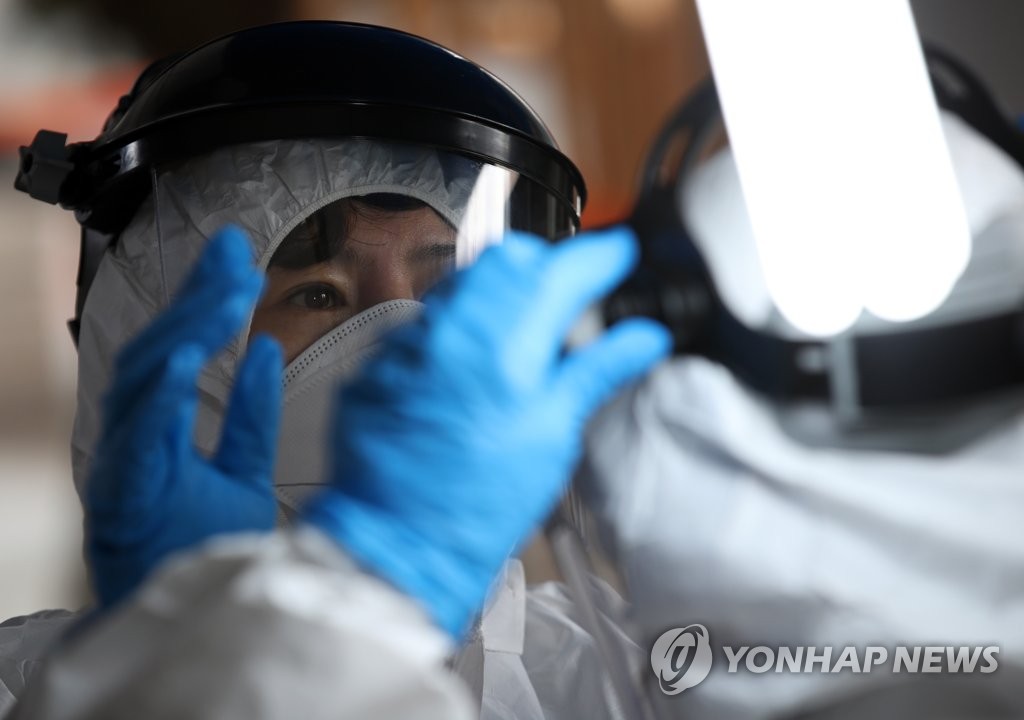资料图片：3月12日，在首尔九老区卫生站，医务人员为检查新冠病例做准备。 韩联社