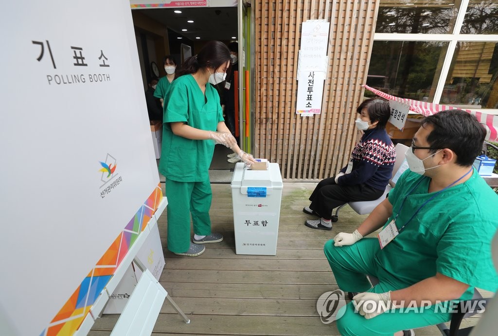 A medical worker casts her ballot at a special polling station set up in a facility in the virus-hit southeastern city of Gyeongsan on April 11, 2020, where COVID-19 patients with mild symptoms are being treated. (Yonhap)