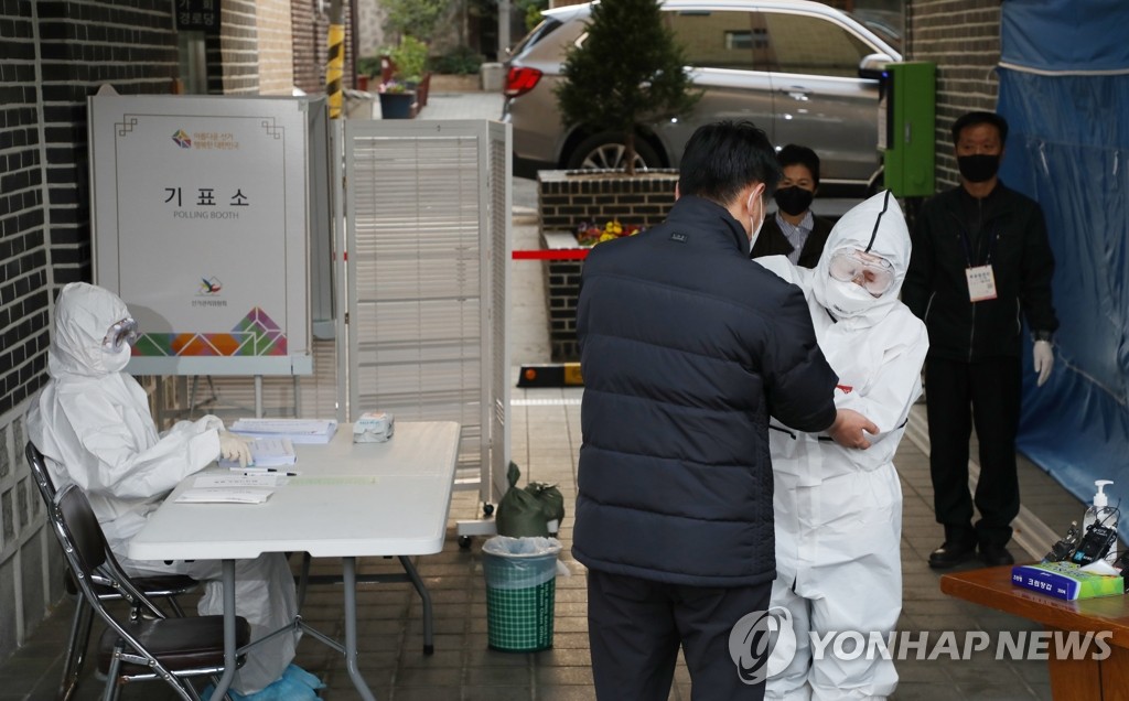 A South Korean man in self-isolation gets his temperature checked at a polling station in Seoul on April 15, 2020. (Yonhap)