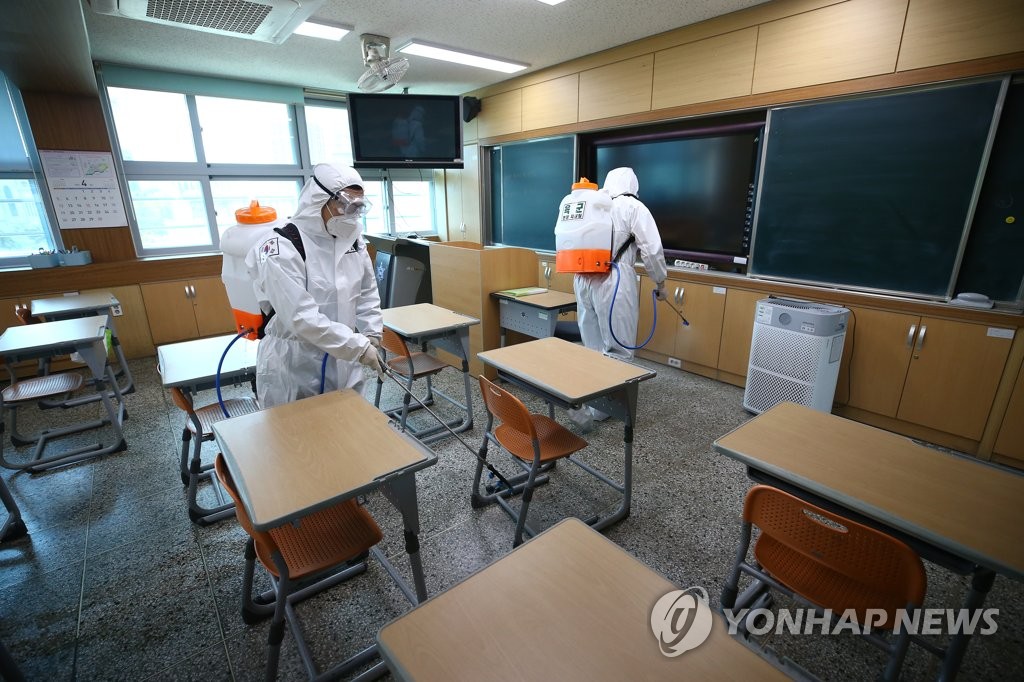 Military officials carry out a disinfection operation at a middle school in Daegu, some 300 kilometers south of Seoul, to prevent the spread of the new coronavirus. (Yonhap)