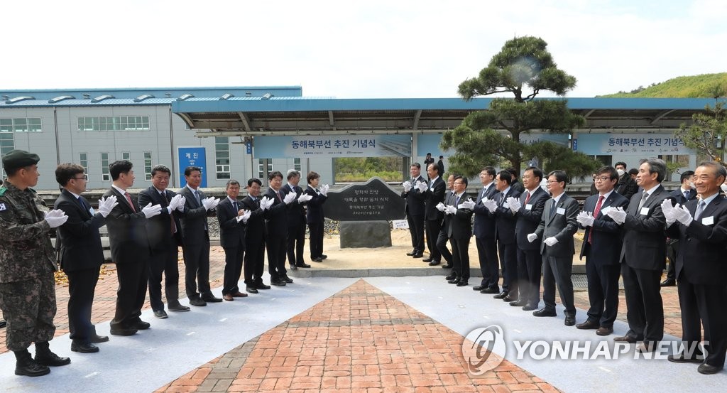 Transportation Minister Kim Hyun-mee (10th from L) and Unification Minister Kim Yeon-chul (10th from R) pose next to a stone marker to commemorate the official start of a project aimed at reconnecting inter-Korean railways at a ceremony held at Jejin Station on South Korea's east coast on April 27, 2020. (Pool photo) (Yonhap)