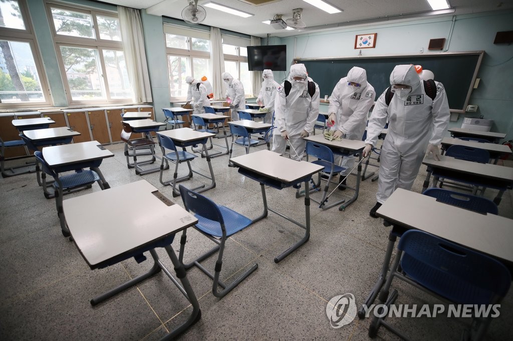 Quarantine officials from the Army disinfect a high school classroom in Daegu, some 300 kilometers southeast of Seoul, on April 28, 2020. (Yonhap) 