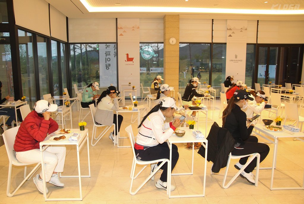 In this photo provided by the Korea Ladies Professional Golf Association (KLPGA) on May 14, 2020, players eat their lunch on separate tables in the dining area at Lakewood Country Club in Yangju, Gyeonggi Province, after the first round of the 42nd KLPGA Championship. (Yonhap)