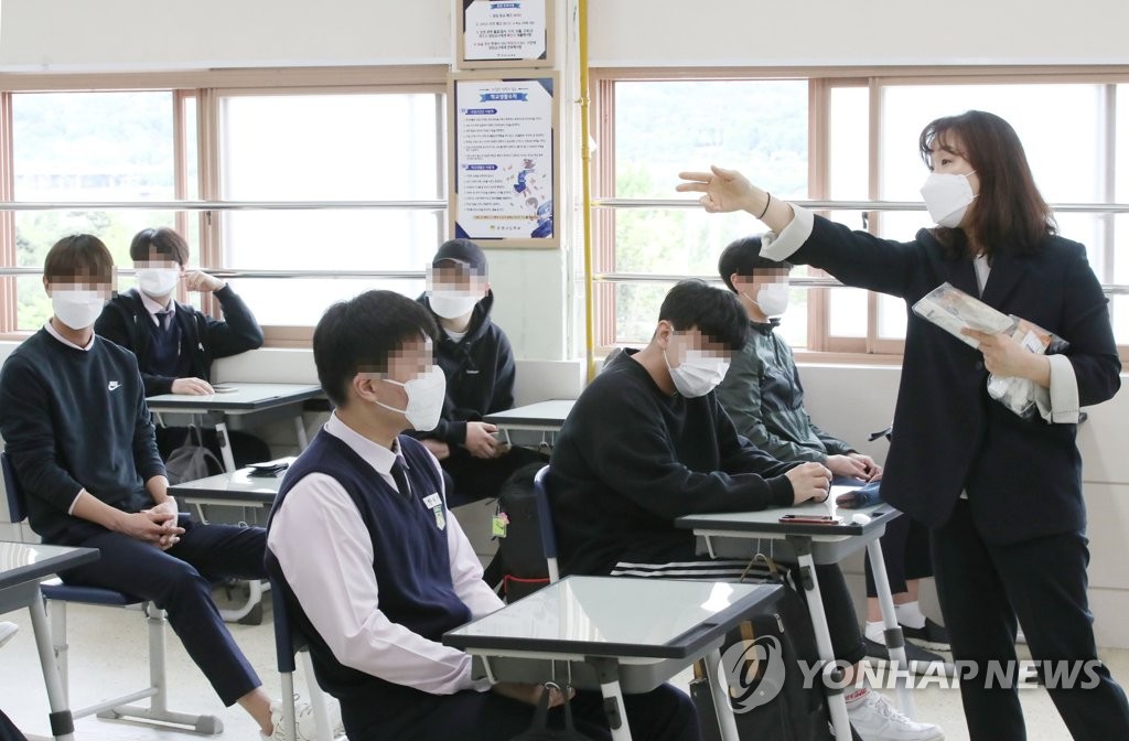 A teacher at a high school in Seoul explains quarantine measures to high school third graders on May 20, 2020, as South Korea reopened schools following a monthslong closure over the new coronavirus. (Yonhap)