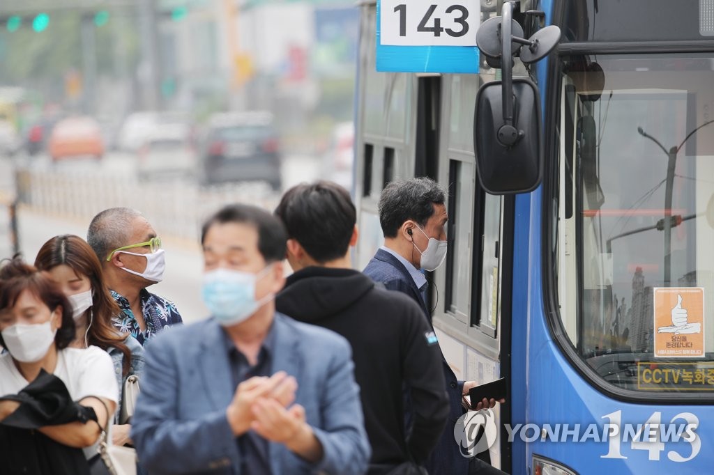 Pedestrians are seen wearing masks at a bus stop in the southern Seoul ward of Seocho on May 25, 2020. (Yonhap) 