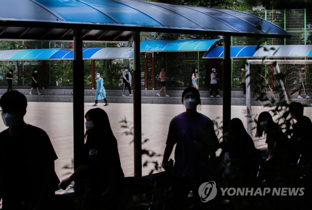 Students and teachers of a high school in northern Seoul wait in line to be tested for the new coronavirus at a makeshift clinic on June 8, 2020, after one of its students tested positive for the virus a day earlier. (Yonhap)