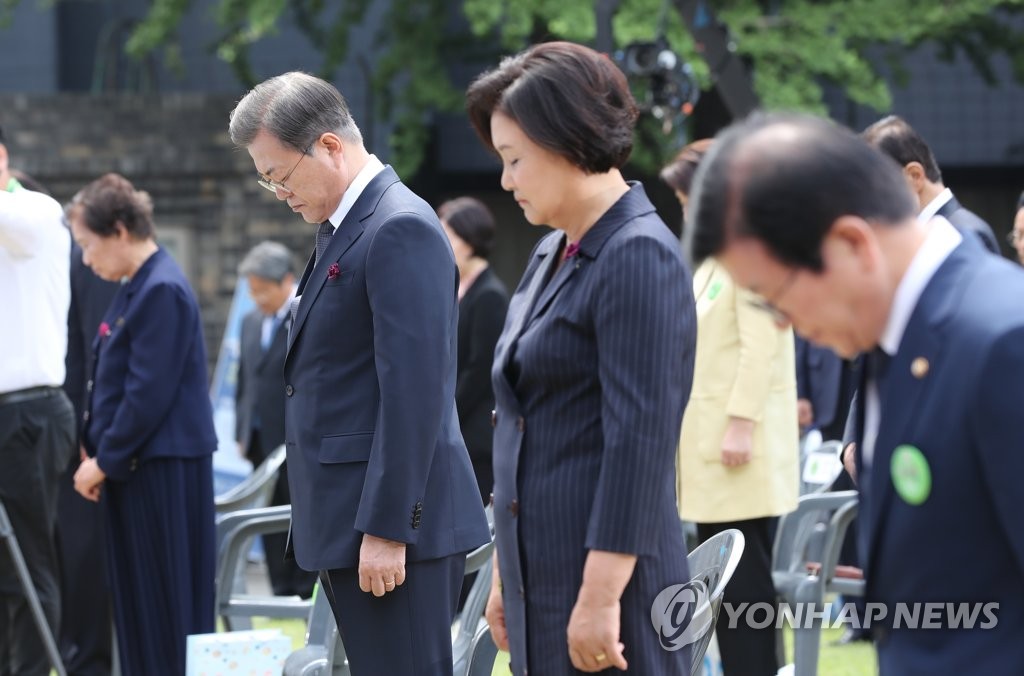 President Moon Jae-in (L) and first lady Kim Jung-sook bow their heads in a silent tribute during a ceremony to mark the 33rd anniversary of the June 10 Democratic Protest held at the Democracy and Human Rights Memorial Hall in central Seoul on June 10, 2020. (Yonhap)