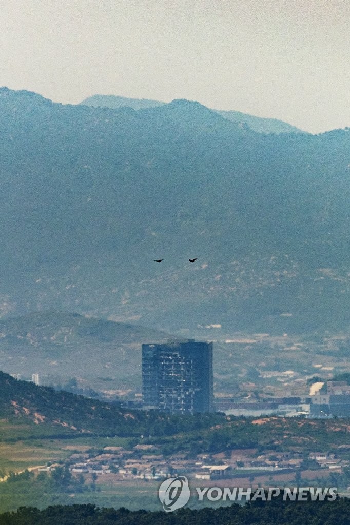 In this file photo taken from the South Korean border city of Paju on June 22, 2020, birds fly over the demolished inter-Korean liaison office in the North Korean border town of Kaesong after the North destroyed the building on June 16. (Yonhap)