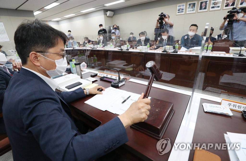 This photo shows Park Joon-shik, chairman of the Minimum Wage Commission, banging the gavel during a plenary session at the government complex in Sejong on July 13, 2020. (Yonhap)