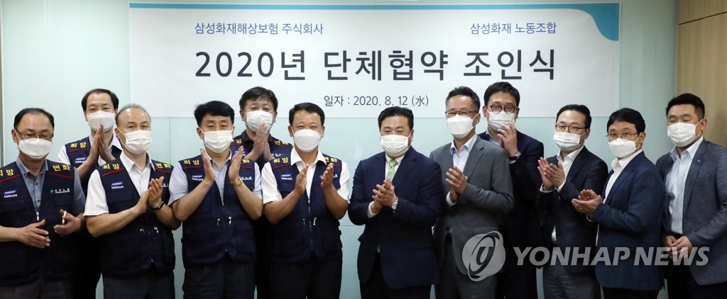 Executives and union members of Samsung Fire & Marine Life Insurance Co. pose for a photo after signing a collective bargaining agreement at the company's headquarters in Seoul on Aug. 12, 2020. (Yonhap)