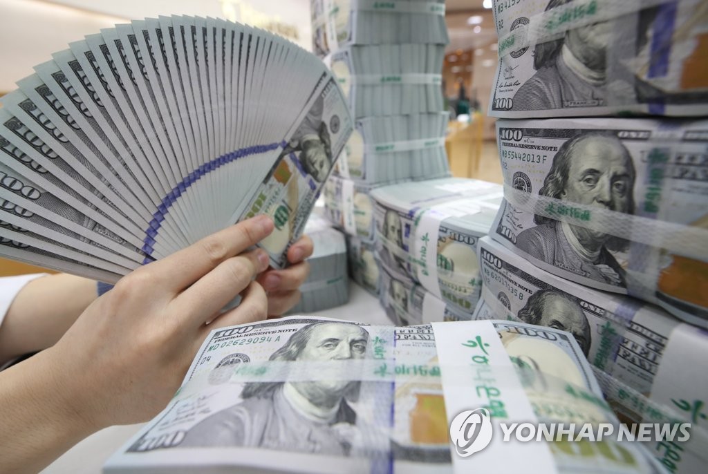 Un employé de la Hana Bank à Séoul inspecte des billets de banque américains avant leur mise en circulation sur le marché financier local. (Photo d'archives Yonhap)