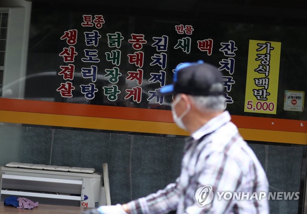 A man wearing a mask passes by a restaurant in Daejeon, 164 kilometers south of Seoul, that closed its doors on Sept. 11, 2020. (Yonhap)