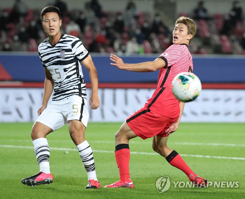 Kwon Kyung-won (L) of the South Korean men's senior national football team clears the ball ahead of Cho Gue-sung of the under-23 national team during their exhibition match at Goyang Stadium in Goyang, Gyeonggi Province, on Oct. 12, 2020. (Yonhap)