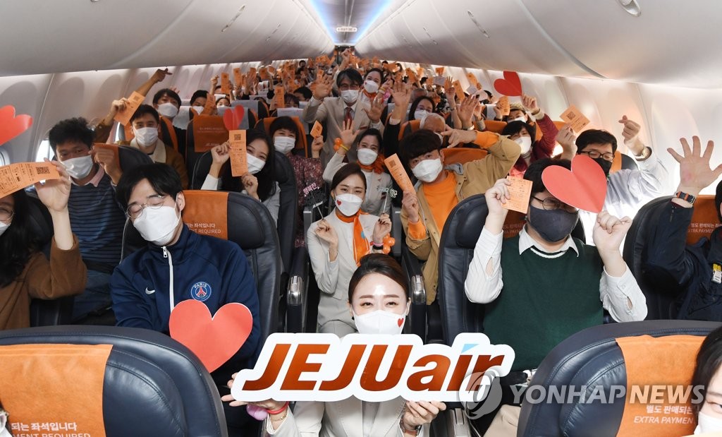 This photo, provided by the Incheon International Airport press pool, shows passengers and flight attendants on a Jeju Air flight to nowhere on Oct. 23, 2020. (Yonhap)