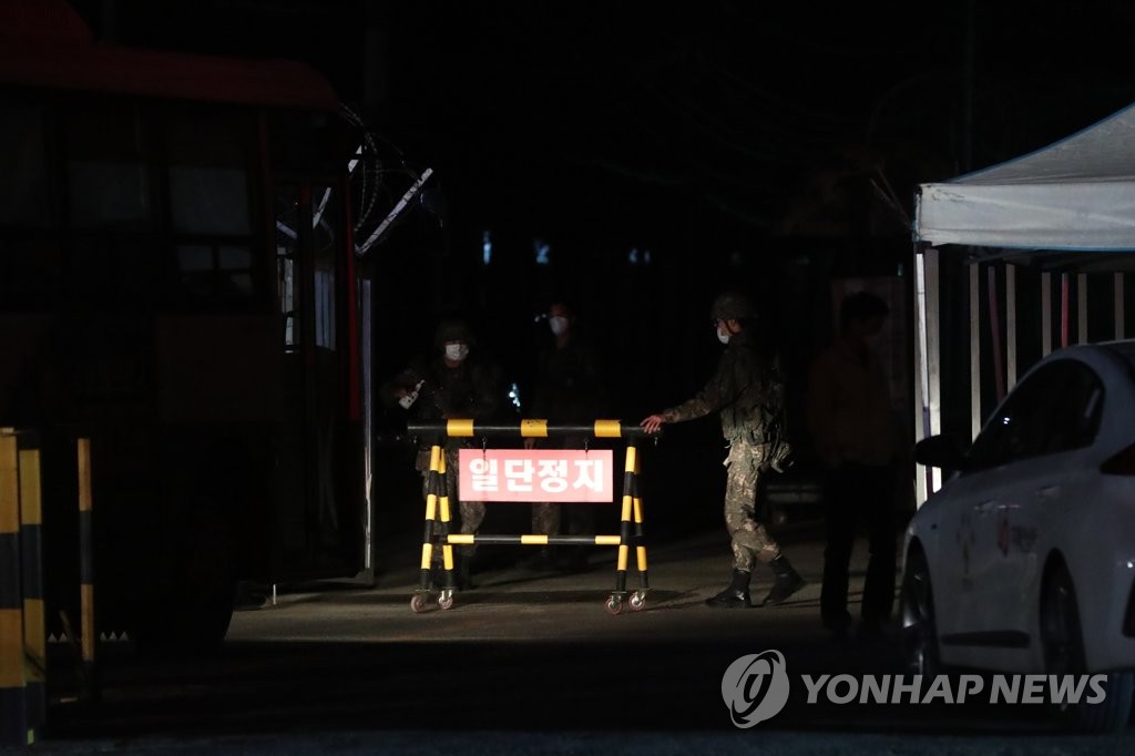 Soldiers open the front gate of an Army boot camp in the northern county of Yeoncheon on Nov. 25, 2020, to allow the entry of health authorities after dozens of newly enlisted soldiers tested positive for the new coronavirus. (Yonhap)