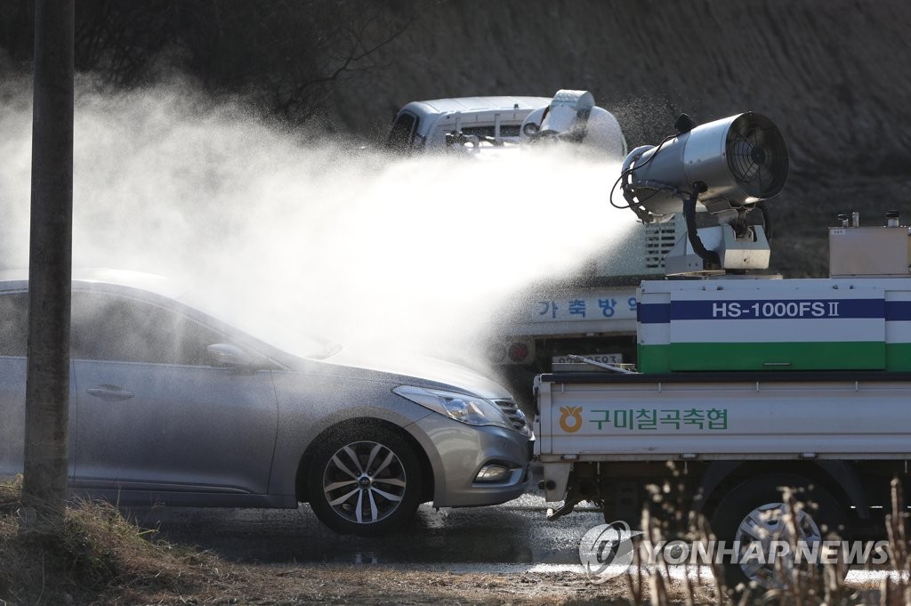 Agricultural officials disinfect an automobile near a farm located in Sangju, 270 km southeast of Seoul, on Dec. 2, 2020. (Yonhap)