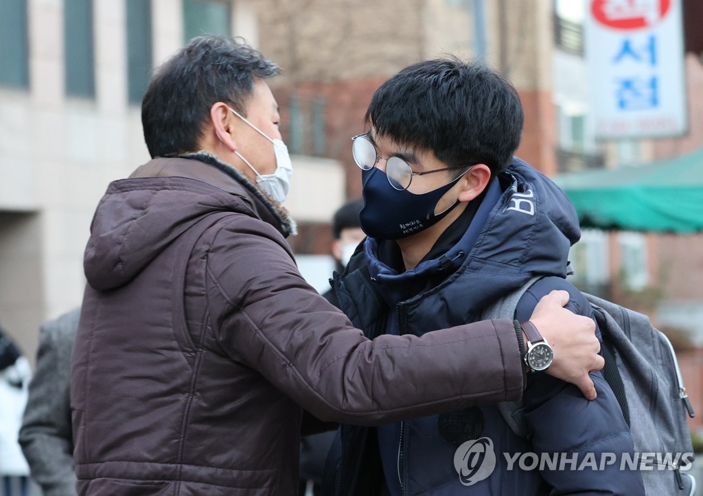 A father wearing a protective mask sees his son off to a venue of the College Scholastic Ability Test (CSAT) in central Seoul on Dec. 3, 2020. (Yonhap)