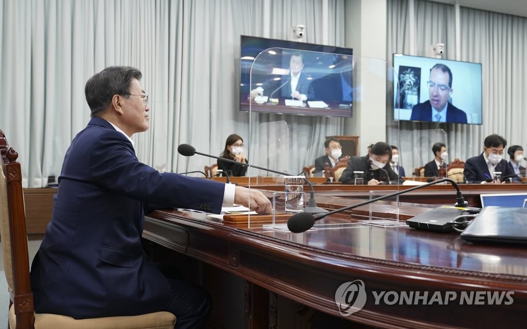 President Moon Jae-in (L) talks with Moderna CEO Stephane Bancel (on the monitor) via videoconference at the presidential office in Seoul on Dec. 28, 2020, in this photo provided by the office. (PHOTO NOT FOR SALE) (Yonhap)