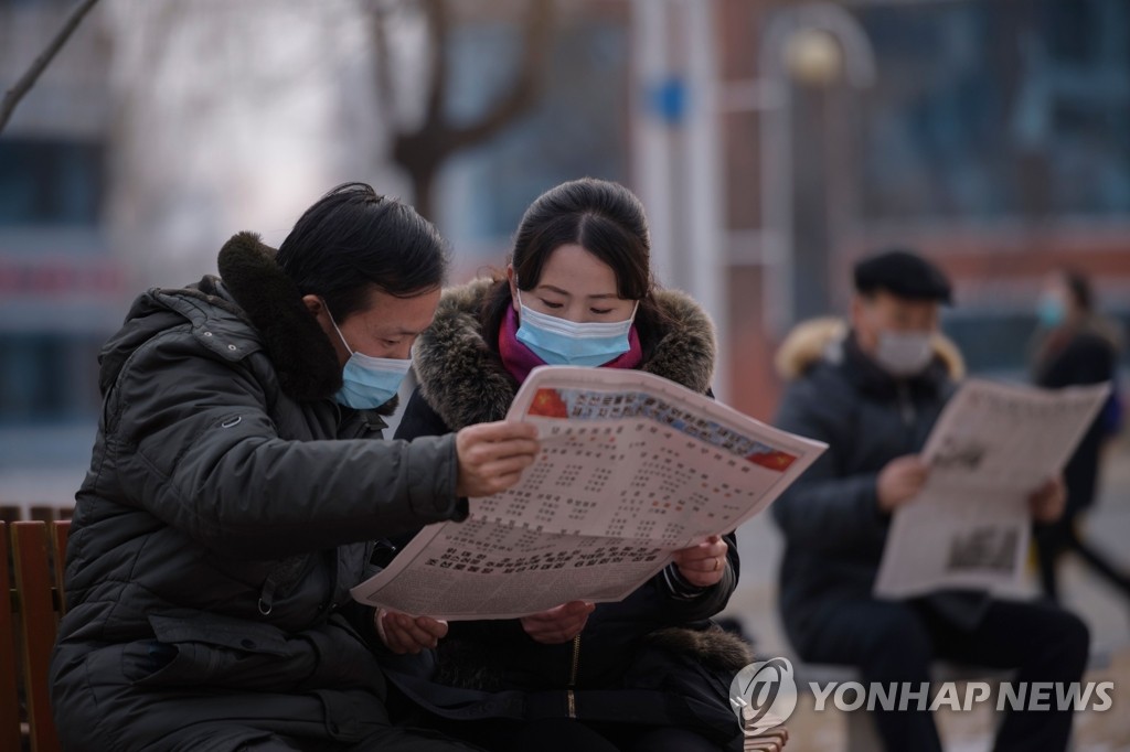 노동신문 읽고 있는 평양 주민들