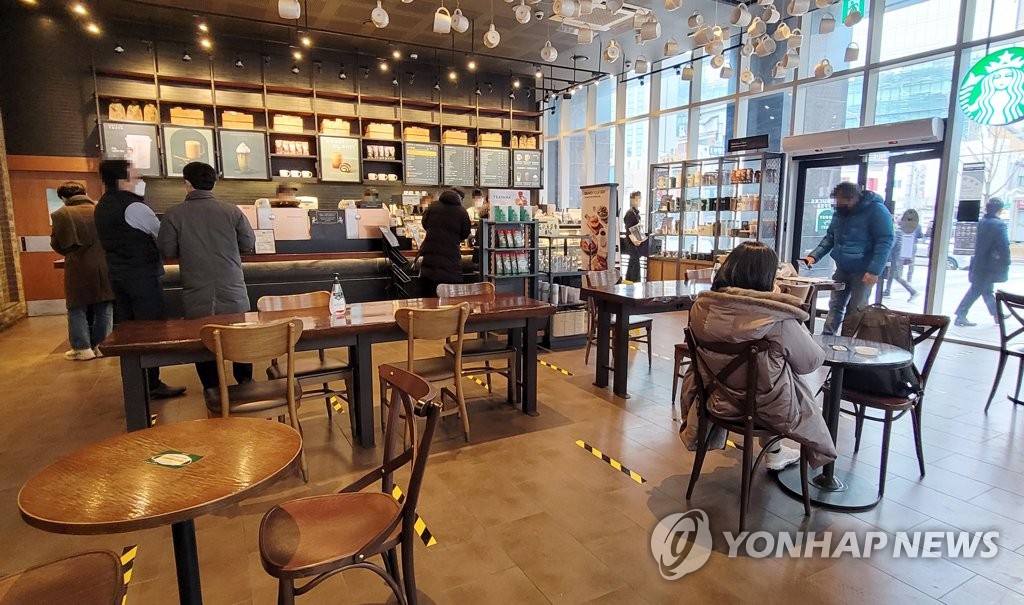 １８日からカフェで午後９時まで店内飲食ができるようになった。ソウル市内のコーヒーチェーン店＝１８日、ソウル（聯合ニュース）